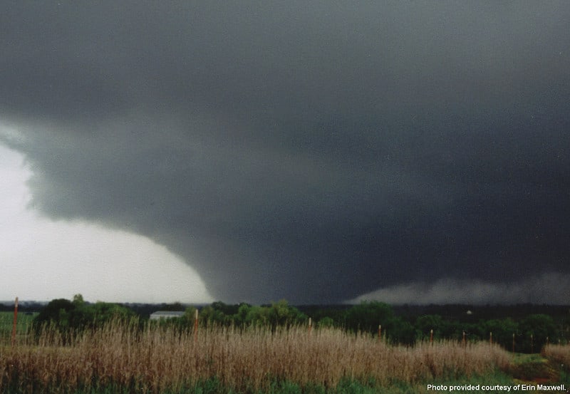 Un tornado oscura il cielo sopra un campo di grano.