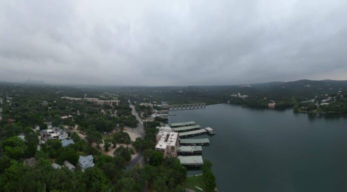 Il lago Austin, la diga Tom Miller e le colline della parte occidentale di Austin, in Texas, in una mattinata nuvolosa e nebbiosa.