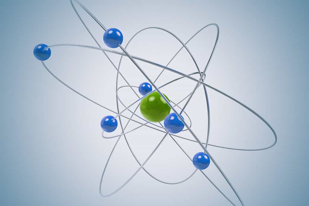 Modello atomico 3D isolato con particelle verdi e blu.  Il nucleo centrale è circondato da una nuvola di elettroni caricati negativamente.