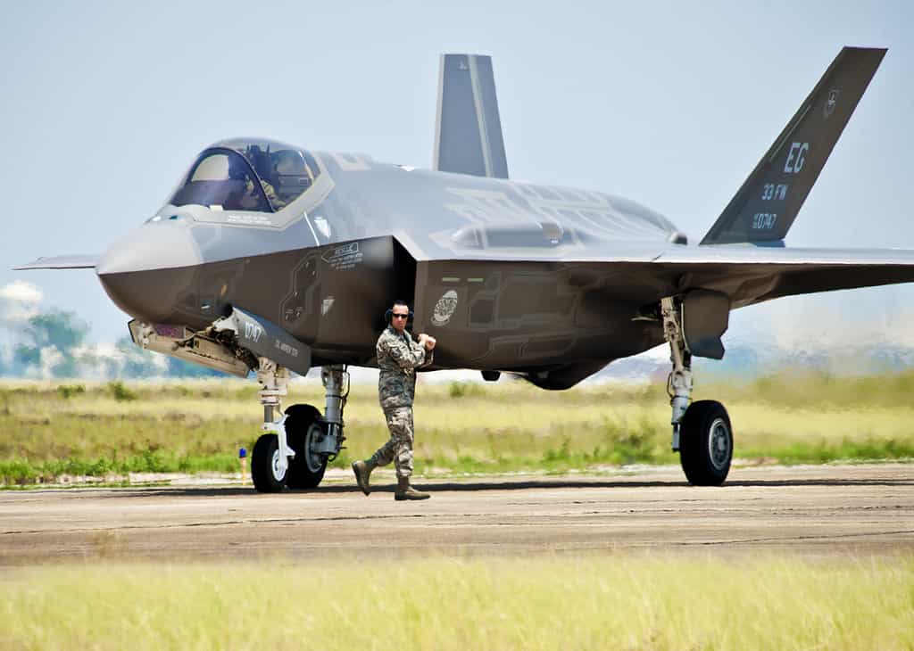 Un manutentore di velivoli della 33rd Fighter Wing si muove accanto al più nuovo velivolo del Dipartimento della Difesa, il caccia d'attacco congiunto F-35 Lightning II dell'aeronautica statunitense (JSF), prima di dare al pilota l'ordine di rullare l'aereo alla base aerea di Eglin, Fla., 14 luglio 2011.