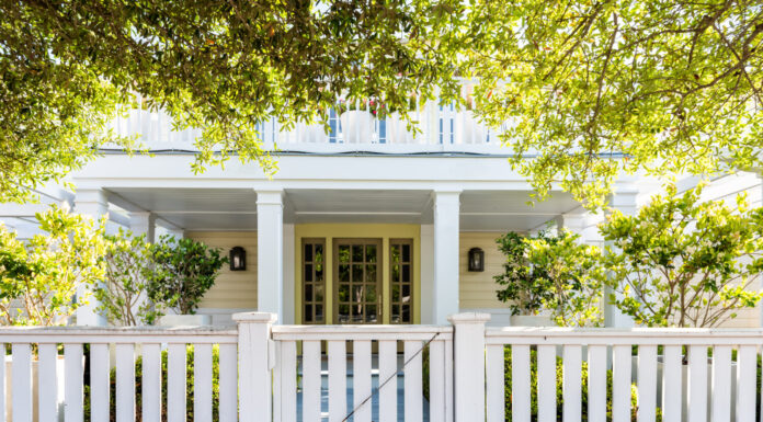 Architettura in legno di legno della spiaggia bianca della casa, cancello della porta sul cortile del portico anteriore con alberi verdi, casa per le vacanze, recinzione