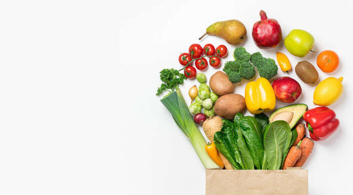 Sfondo di cibo sano.  Cibo sano in verdure e frutta in sacchetto di carta su bianco.  Consegna di cibo, concetto di supermercato alimentare