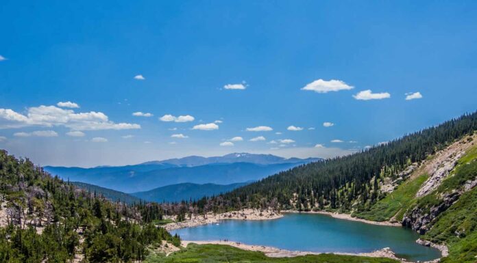 Il lago e i boschi appena sotto la neve che si scioglie del ghiacciaio St. Mary in Colorado.