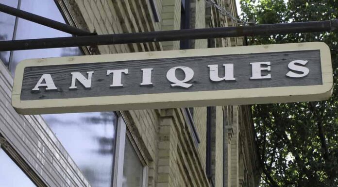 Semplice cartello appeso all'esterno del vecchio edificio in mattoni con negozio di antiquariato