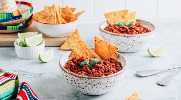 Chili con carne in ciotole con tortilla chips su sfondo di marmo grigio.  Piatto tradizionale della cucina messicana.  Messa a fuoco selettiva