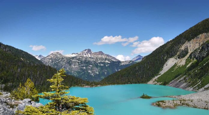 Un bellissimo lago glaciale in Canada.  Il turchese lago Joffre è circondato dalla foresta pluviale.  Cime delle montagne sullo sfondo.  Parco provinciale dei laghi Joffre.  Columbia Britannica, Canada.