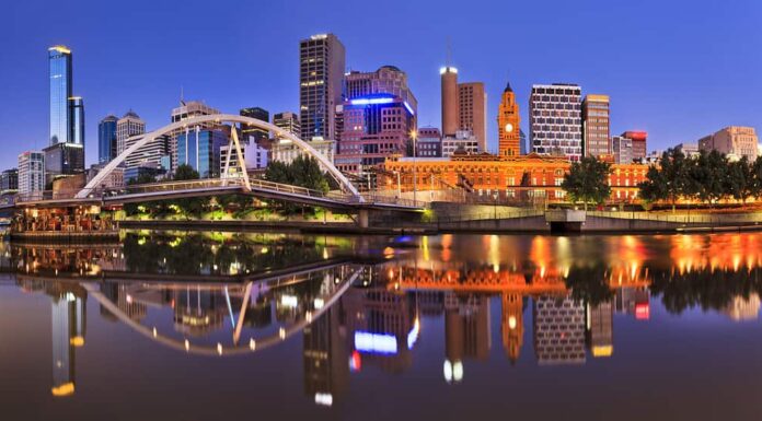 La linea cittadina del CBD di Melbourne all'alba riflette le luci luminose dell'illuminazione della città nelle acque tranquille del fiume Yarra