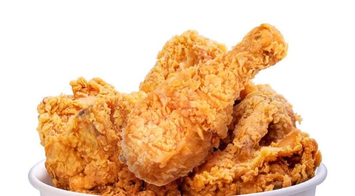 Pollo fritto in secchio di carta isolato su sfondo bianco, pollo fritto su bianco con tracciato di ritaglio.