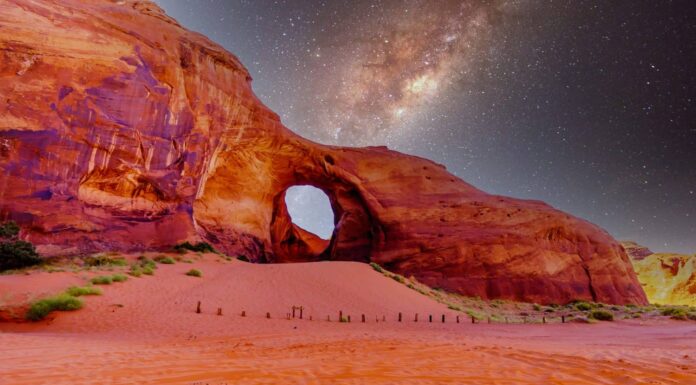 Cielo stellato dietro l'orecchio del vento, un buco in una formazione rocciosa nel parco tribale Navajo Monument Valley al confine tra Utah e Arizona, Stati Uniti