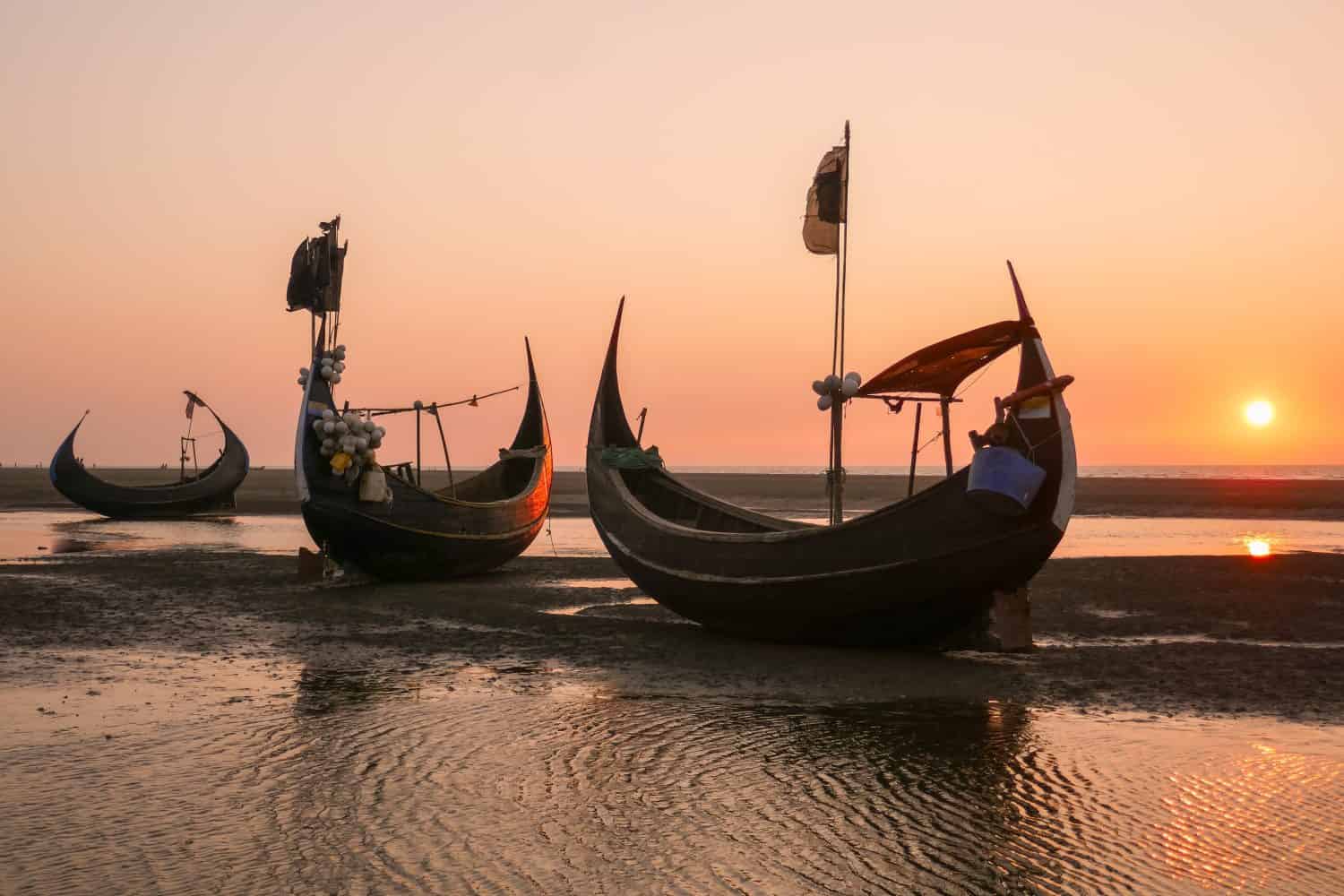 Tramonto con bellissime barche da pesca tradizionali in legno conosciute come barche lunari sulla spiaggia vicino a Cox's Bazar nel Bangladesh meridionale