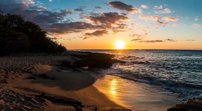Tramonto sulla sabbia bianca della spiaggia di Kapalaoa sulla baia di Anaeho'omalu, isola di Hawaii, Hawaii, Stati Uniti