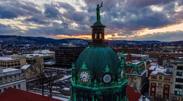 Una ripresa aerea di un tempio verde nel centro di Binghamton, durante un tramonto arancione