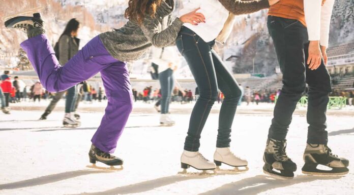 Ragazze adolescenti divertenti e ragazzo che pattinano all'aperto, pista di pattinaggio