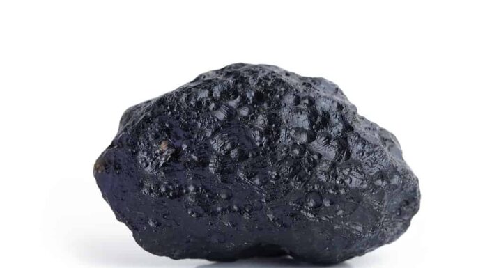 Roccia di pietra nera meteorite isolata su sfondo bianco.