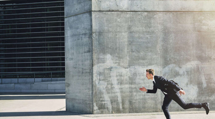 Uomo d'affari su uno skateboard che va avanti velocemente