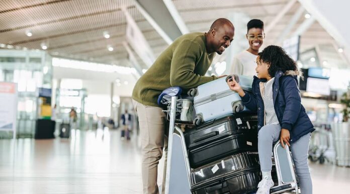 Famiglia turistica con carrello portabagagli all'aeroporto