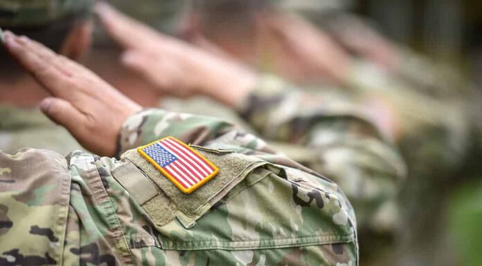 Dettaglio girato con la bandiera americana sull'uniforme del soldato, che fa il saluto d'onore durante la cerimonia militare