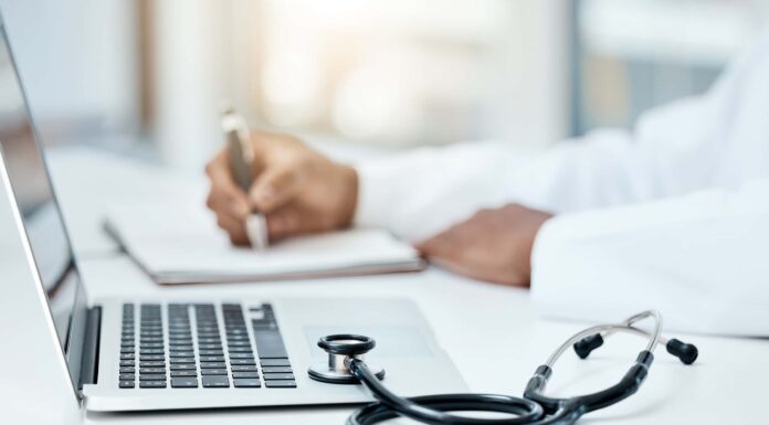 Laptop, stetoscopio e medico scrivono su un taccuino per la pianificazione della ricerca o l'innovazione della tecnologia medica nell'ufficio ospedaliero.  Operatore medico sanitario, appunti sul libro della strategia di ricerca e comunicazione online
