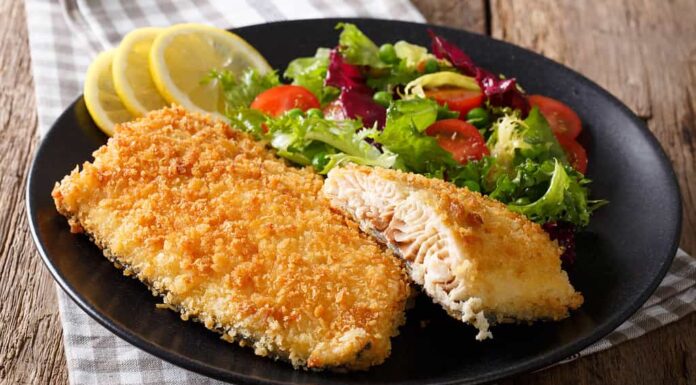 Gustoso filetto di pesce arrosto nel pangrattato e primo piano di verdure fresche.  orizzontale