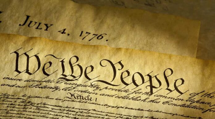 We the People è l'incipit del preambolo della Costituzione degli Stati Uniti.  Il documento sottostante è una copia della Dichiarazione di Indipendenza con la data 4 luglio 1776 in evidenza.