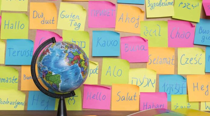 Studiare il concetto di lingue, un globo e note di colore con la parola Ciao in diverse lingue.