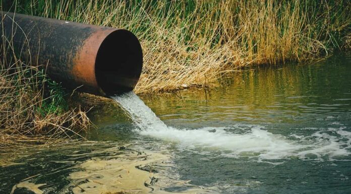 Drenaggio delle acque reflue dal tubo nel fiume, fiumi di inquinamento ed ecologia