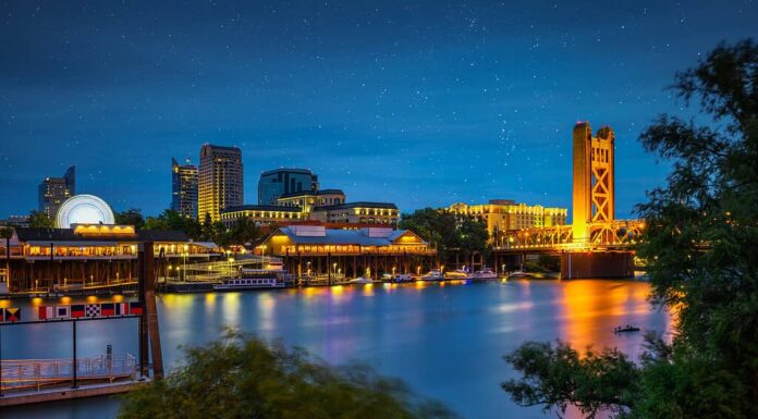 Il Gold Tower Bridge e il fiume Sacramento a Sacramento, California, fotografati dal River Walk Park di notte con le stelle nel cielo.