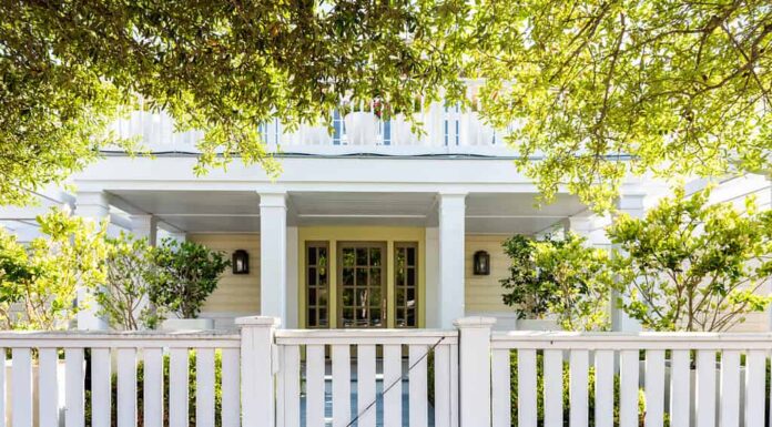 Architettura in legno di legno della spiaggia bianca della casa, cancello della porta sul cortile del portico anteriore con alberi verdi, casa per le vacanze, recinzione