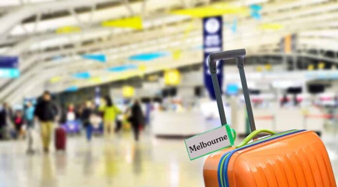 Melbourne, Australia.  Valigia arancione con etichetta all'aeroporto.