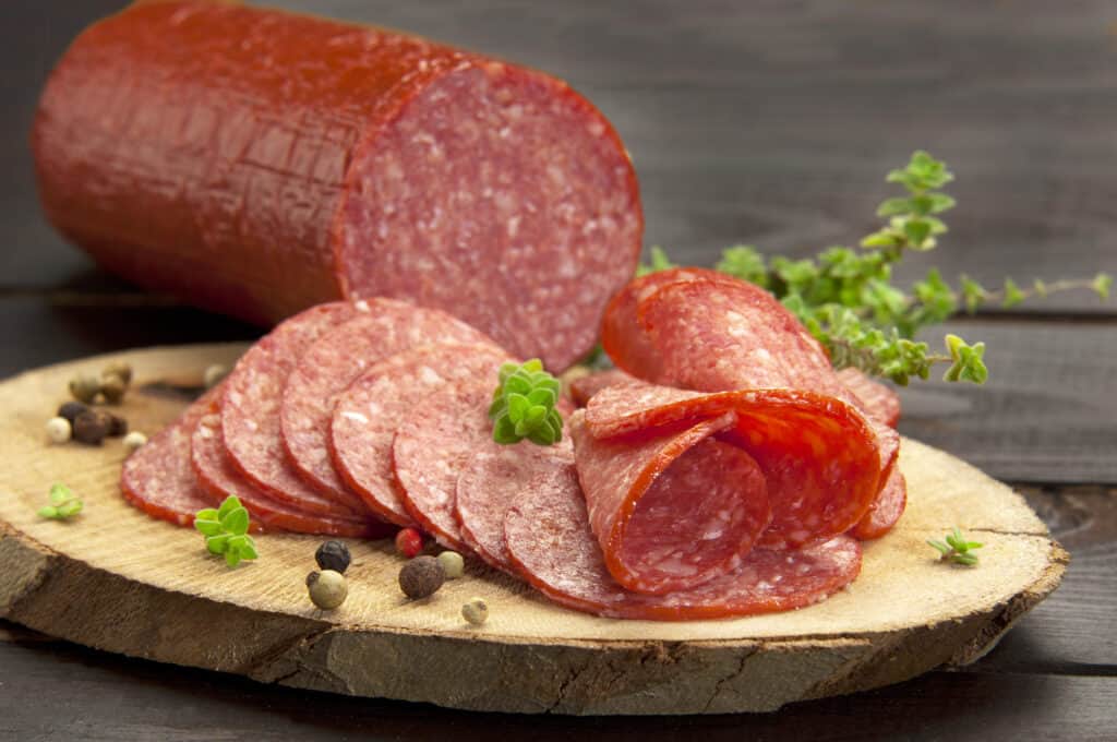 salame affettato su pezzo di legno