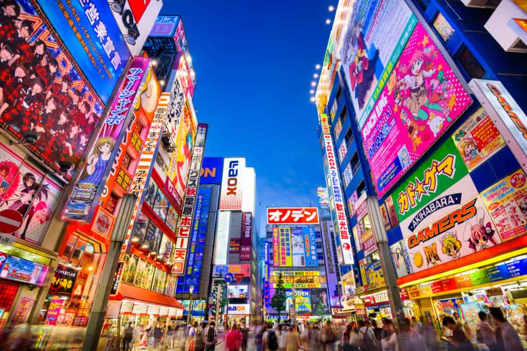 TOKYO, GIAPPONE - 1 AGOSTO 2015: La folla passa sotto i cartelli colorati ad Akihabara.  Lo storico quartiere dell'elettronica si è evoluto in un'area commerciale per videogiochi, anime, manga e articoli per computer.