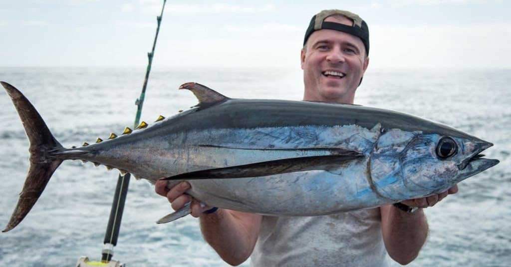 Pescatore felice che tiene grande tonno