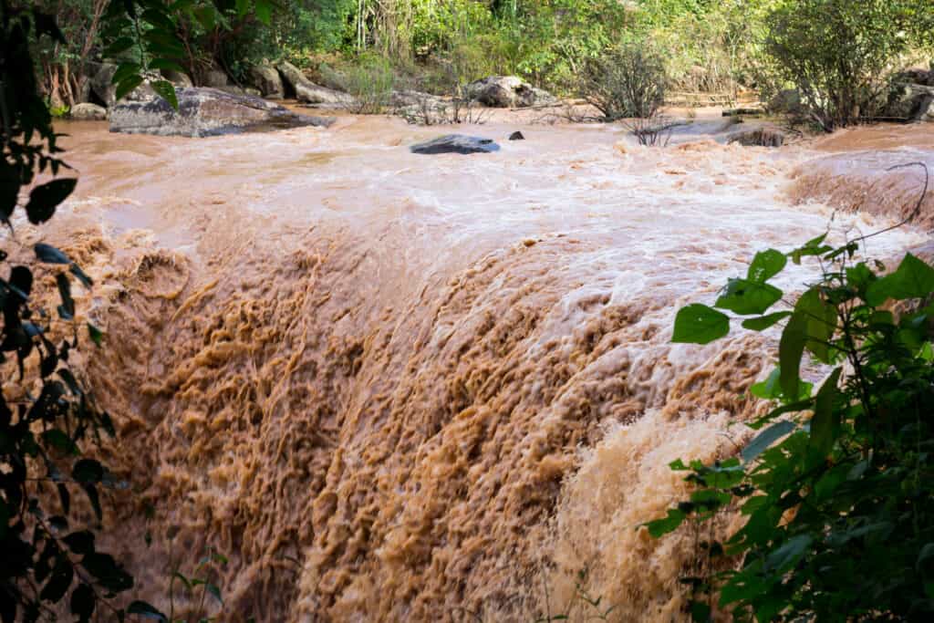 Una cascata di acqua marrone causata da inondazioni improvvise
