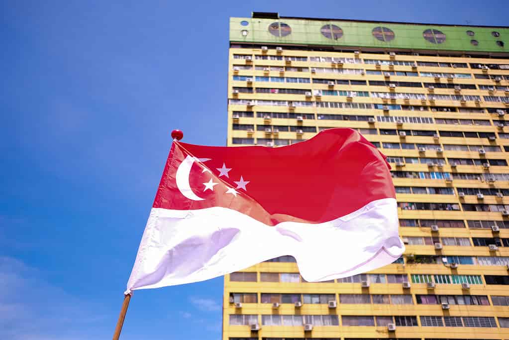 Bandiera di Singapore che sventola nel vento sullo sfondo del vecchio edificio del parco popolare
