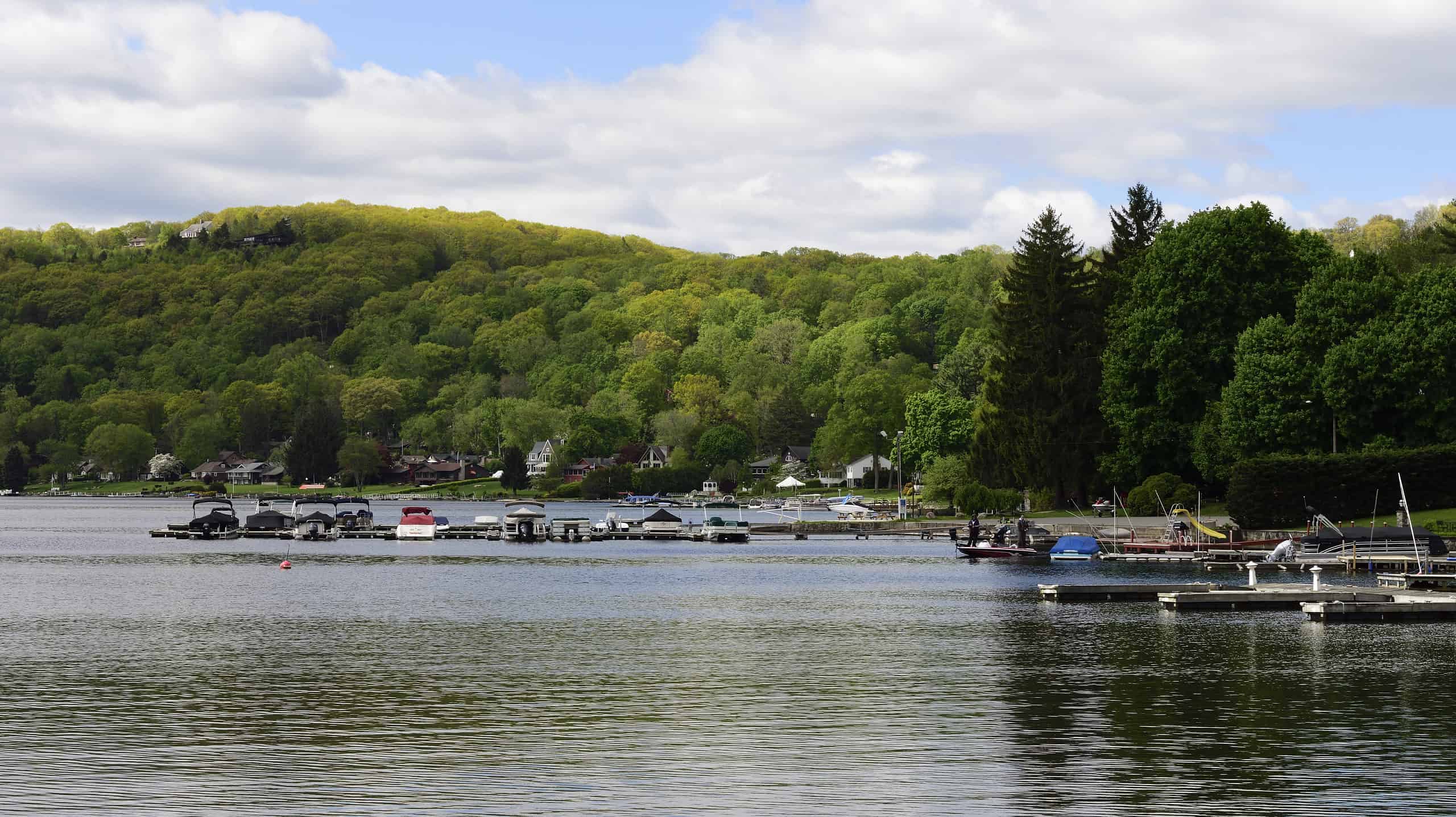 Candlewood Lake in una tranquilla mattinata estiva con barche ormeggiate e montagna sullo sfondo, New Fairfield, Connecticut.