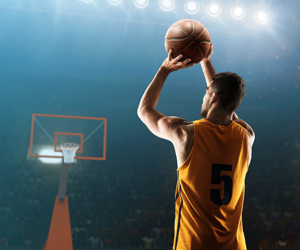 Il giocatore di basket professionista spara un tiro da tre punti