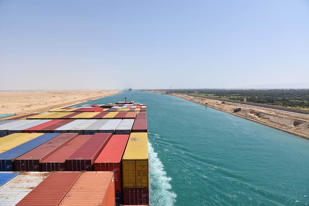 Vista sui container caricati sul ponte della nave da carico.  La nave sta transitando nel canale di Suez sulla sua rotta commerciale internazionale.  Paesaggio del canale di Suez.