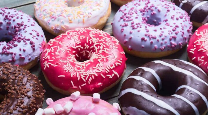 assorted donuts with chocolate frosted, pink glazed and sprinkles donuts.