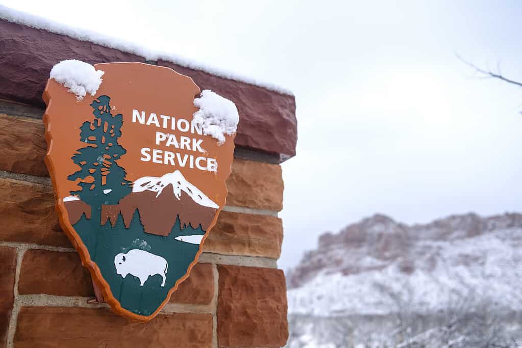 Segno di servizio del parco nazionale sulla parete con neve