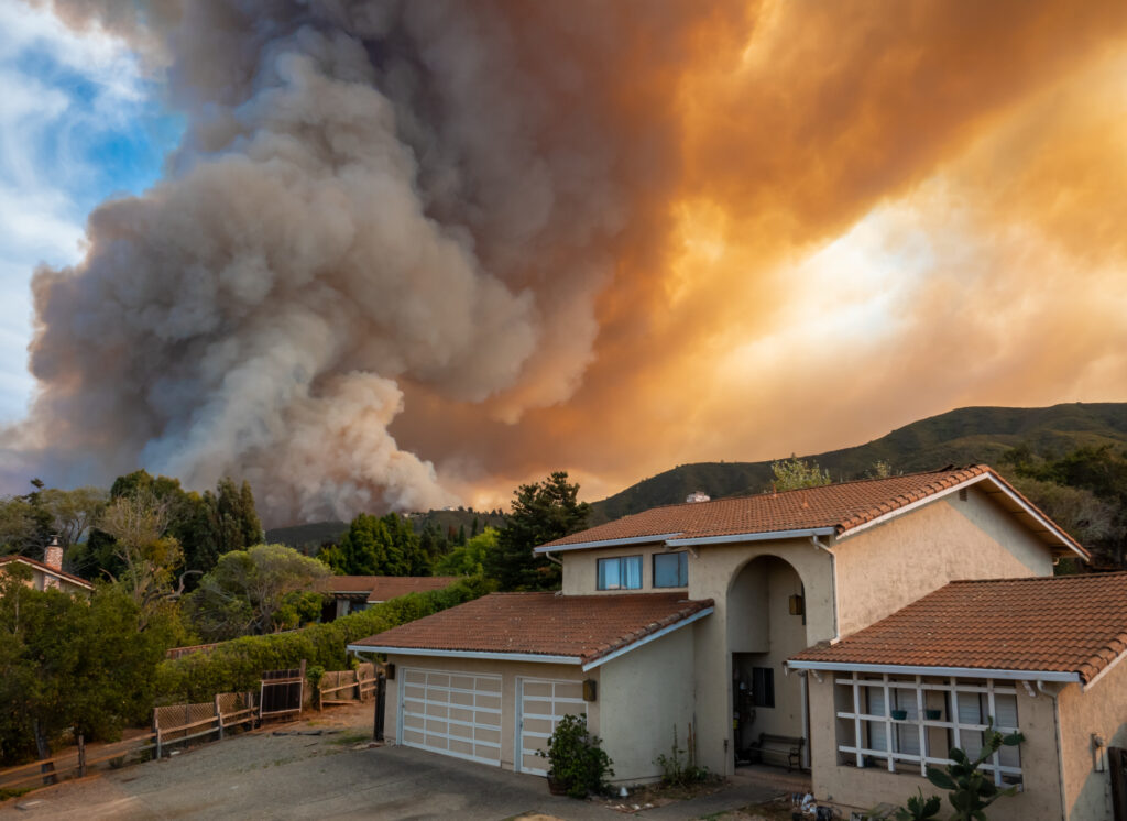 Il "River Fire" californiano di Salinas, nella contea di Monterey, è stato acceso da un fulmine secco il 16 agosto 2020, riempie il cielo di fumo scuro e fiamme mentre brucia vicino a una casa nel suo primo giorno.