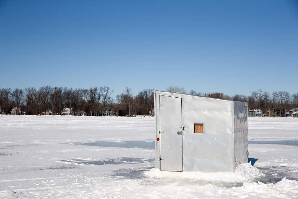 Una baracca di ghiaccio solitaria seduta su un lago ghiacciato.  
