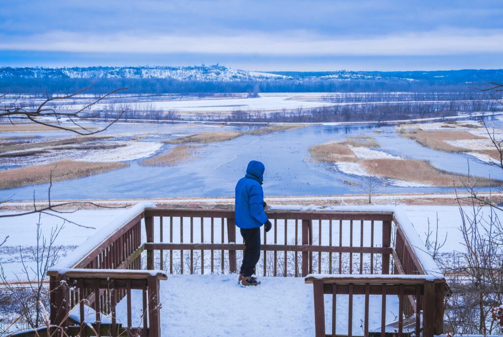 Uomo che guarda il fiume Missouri ghiacciato