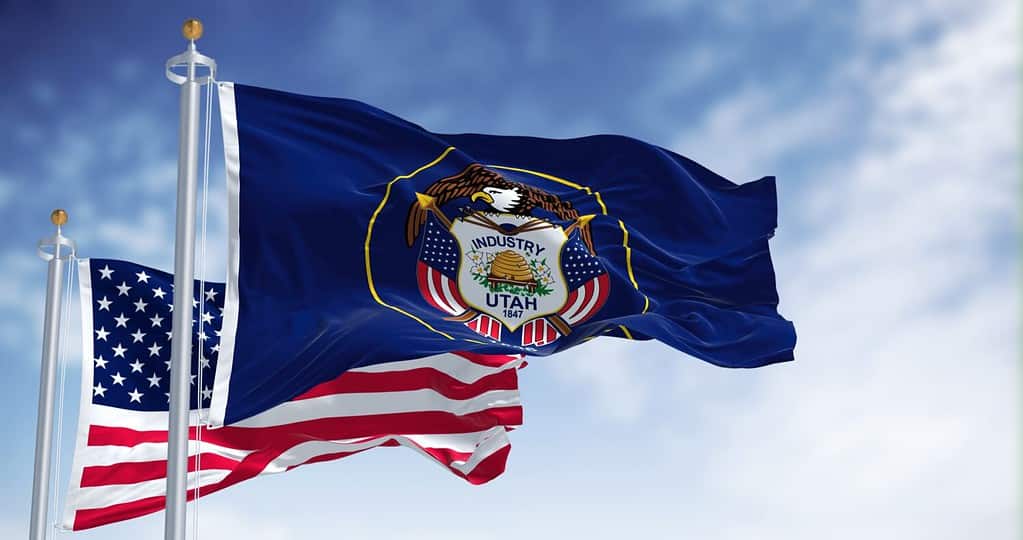 La bandiera dello stato dello Utah sventola insieme alla bandiera nazionale degli Stati Uniti d'America.  Lo Utah è uno stato nella sottoregione Mountain West degli Stati Uniti occidentali