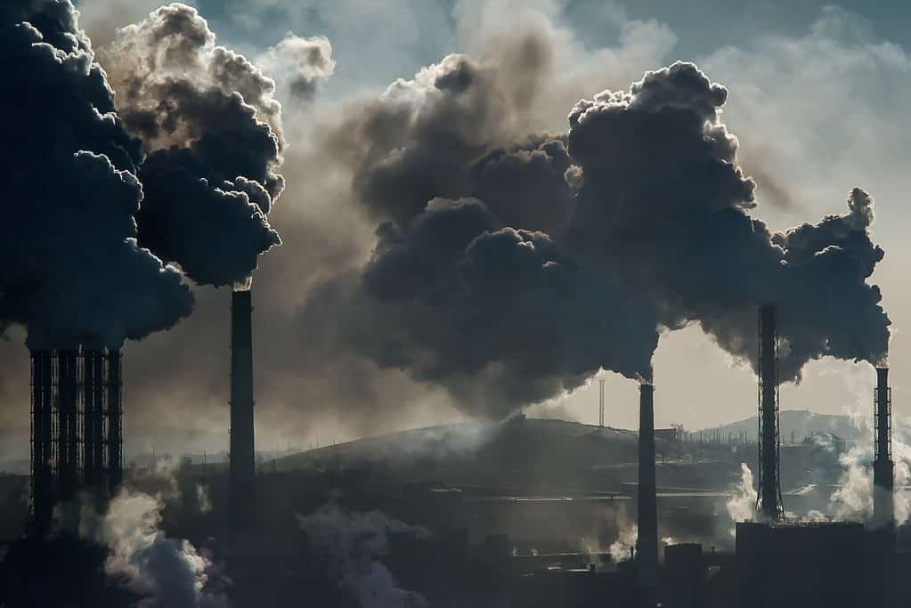 Una nuvola nera di inquinamento emette da una fabbrica