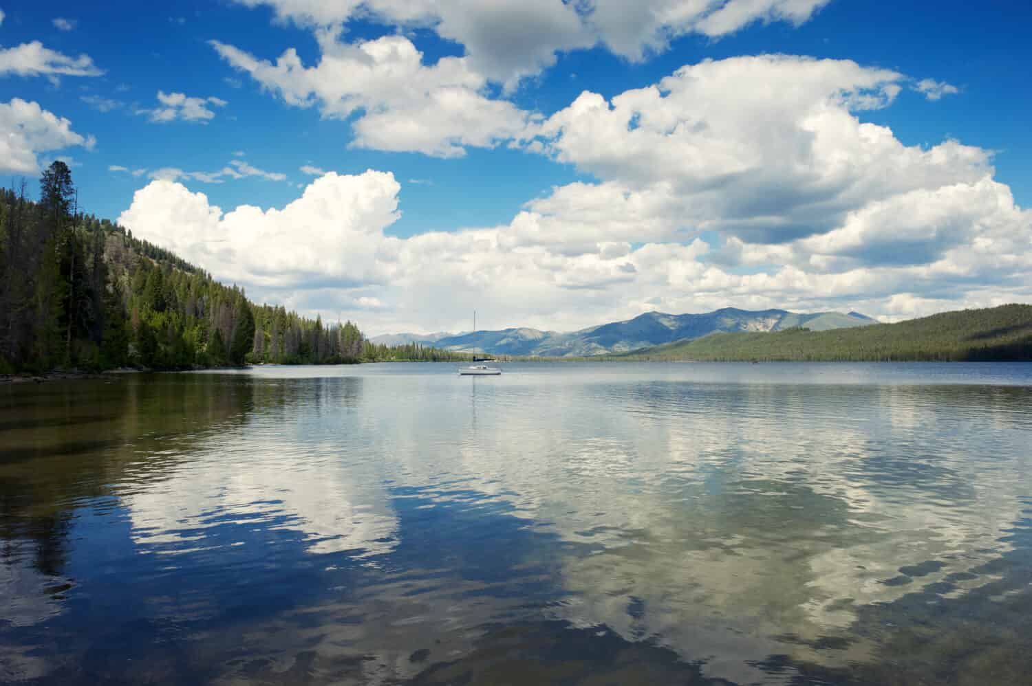 Vista panoramica di nuvole bianche gonfie che si riflettono sulla superficie di un tranquillo lago Alturas nelle Montagne Rocciose dell'Idaho, USA