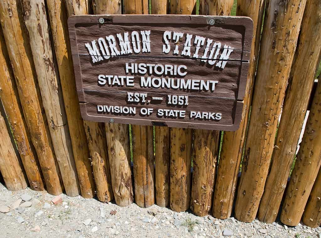 Segno del parco statale della stazione mormone.  Il cartello è realizzato in legno ed è fissato a una staccionata in legno. 