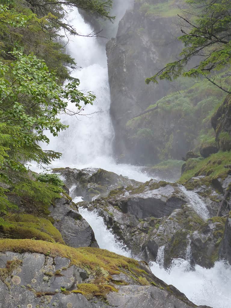 Cascata in un flordo vicino a Skagway, Alaska che cade nell'acqua turchese.