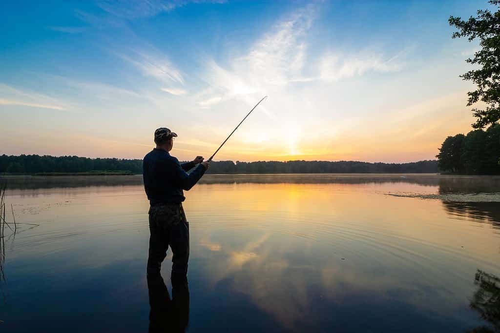 Siluetta del pescatore durante l'alba