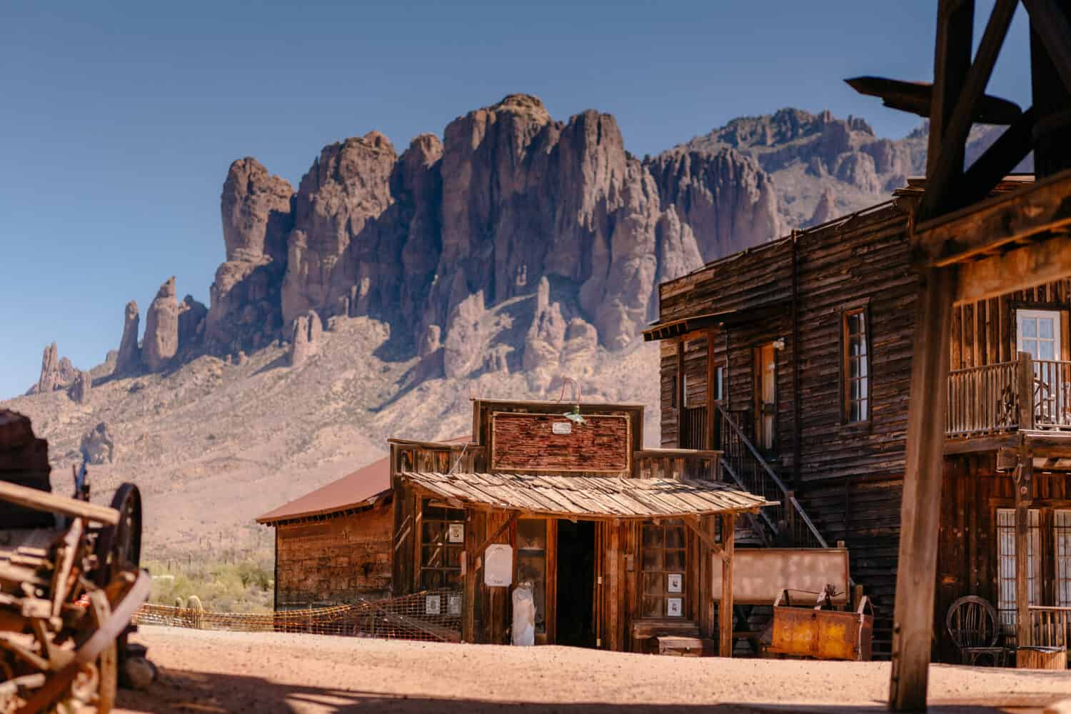 Vecchi edifici in legno occidentali nella città fantasma di Goldfield Gold Mine a Youngsberg, Arizona, Stati Uniti, circondati da cactus