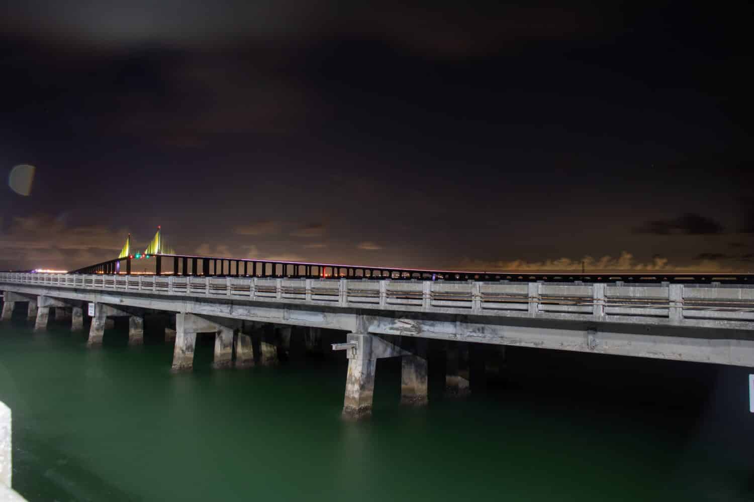 Foto notturne a lunga esposizione delle luci del Tampa Bay Sunshine Skyway Bridge dal molo dei pescatori.